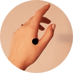Photo of a white woman's hand with a black dot in the soft part between the forefinger and thumb.